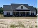 Inviting house with a gray brick base, and a charming front porch perfect for relaxing at 3200 Fowler School Rd., Loris, SC 29569
