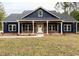 Beautiful blue home featuring dark shutters, a brick base, manicured lawn, and a lovely front porch at 3200 Fowler School Rd., Loris, SC 29569