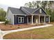 Inviting blue house with a gray brick base, and a charming front porch perfect for relaxing at 3200 Fowler School Rd., Loris, SC 29569