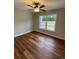 Cozy bedroom boasts hardwood floors, a ceiling fan, and a large window at 3204 Fowler School Rd., Loris, SC 29569