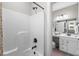 Bright bathroom with a white tub/shower combo and a glimpse of the vanity area with sliding barn door at 379 Mikita Dr., Surfside Beach, SC 29575