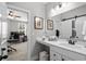 Well-lit bathroom featuring a white vanity, framed mirrors and a glimpse into an adjacent room at 379 Mikita Dr., Surfside Beach, SC 29575