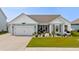 Charming single-story home with blue siding, a well-manicured lawn, and an attached two-car garage at 379 Mikita Dr., Surfside Beach, SC 29575