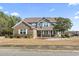 Charming two-story home with a brick facade, landscaped front yard, and inviting front porch at 400 Dog Pen Ct., Myrtle Beach, SC 29588