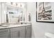 Bathroom featuring a granite countertop, grey cabinetry, decorative mirror, and tiled shower with mosaic accents at 400 Summerwood Ct., Myrtle Beach, SC 29579