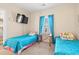 Inviting bedroom featuring two twin beds, a TV, and a window with blue curtains at 4142 Hibiscus Dr. # 20-202, Little River, SC 29566