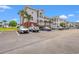 Condo building with a light exterior, multiple levels of private balconies, and a parking area at 4142 Hibiscus Dr. # 20-202, Little River, SC 29566