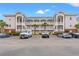 Three-story condo building showing private balconies, well-manicured landscaping, and ample parking at 4142 Hibiscus Dr. # 20-202, Little River, SC 29566