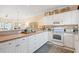 Charming kitchen with white cabinets, countertop decor, and an open view into the living area at 4142 Hibiscus Dr. # 20-202, Little River, SC 29566
