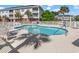 Community pool surrounded by lounge chairs, tables, trees, and multistory buildings at 4142 Hibiscus Dr. # 20-202, Little River, SC 29566