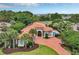 Expansive aerial view showcasing a landscaped property with a pool, brick driveway, and elegant home design at 434 Posada Dr., Myrtle Beach, SC 29572
