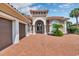 Charming home featuring a red brick driveway, tile roof, arched doorway, and well-manicured landscaping at 434 Posada Dr., Myrtle Beach, SC 29572