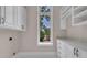 Bright laundry room featuring white cabinetry, granite countertops and a view to the exterior at 434 Posada Dr., Myrtle Beach, SC 29572