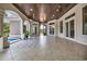 Spacious outdoor patio with wood plank ceiling, tile floor, multiple glass doors, and a view of the pool at 434 Posada Dr., Myrtle Beach, SC 29572