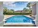 Beautiful blue tiled pool surrounded by manicured landscaping, lush greenery, and a clear blue sky at 434 Posada Dr., Myrtle Beach, SC 29572