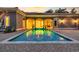 Backyard pool with inviting lighting, surrounded by a brick patio and elegant architecture at dusk at 434 Posada Dr., Myrtle Beach, SC 29572