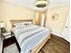 This bedroom features a queen bed with striped bedding, hardwood floors, and a ceiling fan at 4370 Crepe Myrtle Ct. # F, Murrells Inlet, SC 29576
