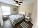 This bedroom features a ceiling fan, a queen bed with a floral pattern, and a white bedside table at 4370 Crepe Myrtle Ct. # F, Murrells Inlet, SC 29576