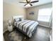 This bright bedroom features a ceiling fan, a queen bed with striped bedding, and hardwood floors at 4370 Crepe Myrtle Ct. # F, Murrells Inlet, SC 29576