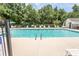 A pristine community pool with lounge chairs and a bath house surrounded by lush trees at 4370 Crepe Myrtle Ct. # F, Murrells Inlet, SC 29576