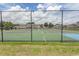 View of fenced tennis and basketball courts with manicured lawns and community buildings beyond at 4370 Crepe Myrtle Ct. # F, Murrells Inlet, SC 29576