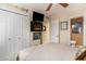 Bedroom featuring a cozy bed, a mounted fireplace below a TV, and an adjacent bathroom, optimizing space and comfort at 4445 Kingsport Rd. # 101, Little River, SC 29566
