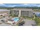 Exterior view of the building with a swimming pool surrounded by lush landscaping and parking at 4445 Kingsport Rd. # 101, Little River, SC 29566
