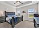 This is a spacious main bedroom with a tray ceiling and a large dark wood bed at 447 Honeyhill Loop, Conway, SC 29526
