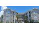 Multi-level condo building featuring charming architecture, balconies, and well-maintained landscaping at 4753 Wild Iris Dr. # 301, Myrtle Beach, SC 29577