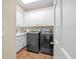 Laundry room featuring tile flooring, overhead white cabinets and modern washer and dryer at 504 Sea Vista Ln., North Myrtle Beach, SC 29582