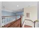 Loft featuring hard wood flooring, white banister, blue accent wall and palm tree artwork at 504 Sea Vista Ln., North Myrtle Beach, SC 29582