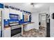 Kitchen featuring sleek appliances, blue accent wall, lots of shelving, and access to the laundry room at 5114 Cowart Ct., Murrells Inlet, SC 29576