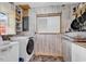 Functional laundry room featuring a washing machine, storage shelves, and a bright window at 5114 Cowart Ct., Murrells Inlet, SC 29576