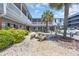 Charming courtyard with outdoor seating surrounded by lush greenery and the building's exterior at 5909 N Ocean Blvd. # 18, North Myrtle Beach, SC 29582