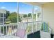 Outdoor patio with white Adirondack chairs overlooking a pool and lush green landscaping and complex buildings at 601 Hillside Dr. N # 1931, North Myrtle Beach, SC 29582