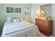 Cozy bedroom features white bedding, wooden dresser, and bright natural light from the window at 601 Hillside Dr. N # 1931, North Myrtle Beach, SC 29582