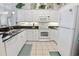 Bright kitchen features tiled floors, granite countertops, white cabinets, and a suite of appliances at 601 Hillside Dr. N # 1931, North Myrtle Beach, SC 29582