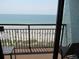 Relaxing balcony view overlooking a sandy beach and calming blue ocean with railings at 6804 N Ocean Blvd. # 1023, Myrtle Beach, SC 29572