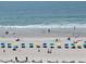 Scenic beach view featuring bright umbrellas, clear ocean, and relaxing beachgoers at 6804 N Ocean Blvd. # 1023, Myrtle Beach, SC 29572