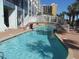 Refreshing outdoor pool with inviting bridge and cozy lounge chairs for relaxation at 6804 N Ocean Blvd. # 1023, Myrtle Beach, SC 29572