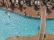 Aerial view of a bright swimming pool with lounge chairs, palm trees, and a bridge at 6804 N Ocean Blvd. # 1023, Myrtle Beach, SC 29572