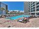 Outdoor pool with lounge chairs, palm trees, and people swimming on a sunny day at 7100 North Ocean Blvd. # 617, Myrtle Beach, SC 29577