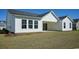 Backyard of the home showcasing the white exterior, sliding doors, and well-kept grassy area at 7180 Shooting Star Way, Myrtle Beach, SC 29579