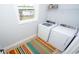 Bright laundry room features modern washer and dryer, window, and colorful rug at 7180 Shooting Star Way, Myrtle Beach, SC 29579