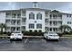 Three-story condominium building featuring reserved parking, manicured landscaping, and classic architectural details at 770 Charter Dr. # C4, Longs, SC 29568