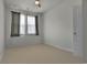 This bedroom has neutral paint, carpet, and one window at 79 S Reindeer Rd., Surfside Beach, SC 29575