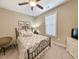 Neutral bedroom features ceiling fan, iron bed frame, dresser, and a window providing natural light at 82 Mingo Dr. # 2D, Pawleys Island, SC 29585