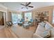 Bright living room with comfortable seating, a ceiling fan, and a sliding glass door leading to the balcony at 82 Mingo Dr. # 2D, Pawleys Island, SC 29585