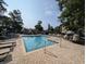 Outdoor swimming pool with lounge chairs surrounding with trees and condos in the background at 82 Mingo Dr. # 2D, Pawleys Island, SC 29585