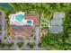 An aerial view of the community clubhouse, pool, parking lot, tennis courts, and bocce ball courts surrounded by trees at 821 Laquinta Loop, Murrells Inlet, SC 29576